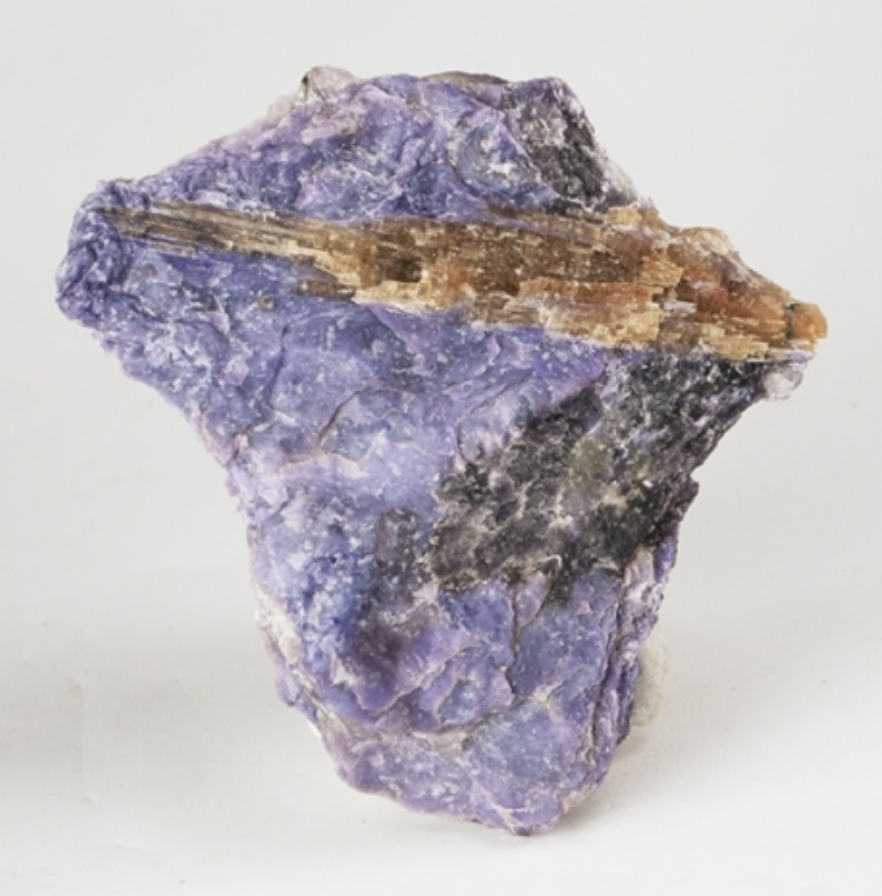 Honey-brown Tinaksite crystals with purple Charoite from the Murunskii Massif, Russia. Photo by Robert M. Lavinsky / iRocks.com, CC BY-SA 3.0 via Wikimedia Commons.