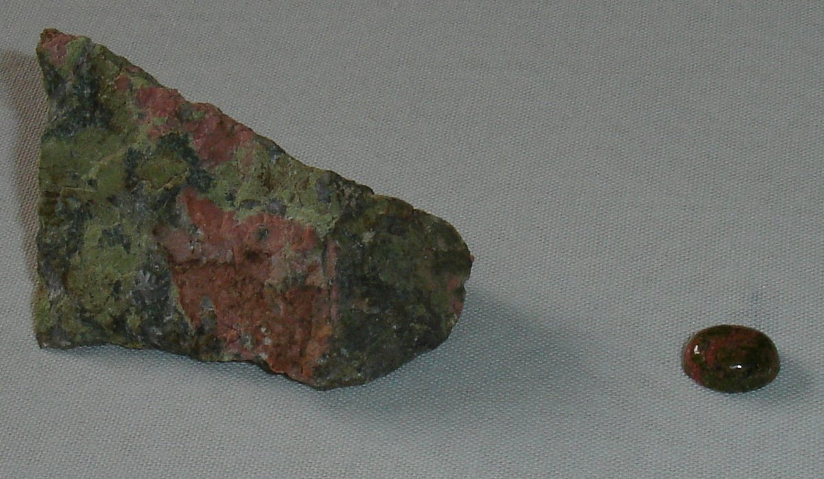 Rough and polished Unakite showing pink feldspar, green Epidote, and pale Quartz. Photo by JohnArmagh, public domain via Wikimedia Commons.