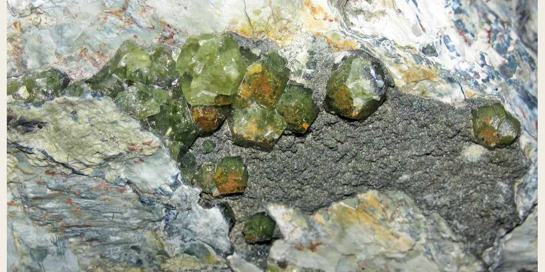 Demantoid garnets from California; photo by James St. John, CC BY 2.0 — Roosters Peacock crystal guide