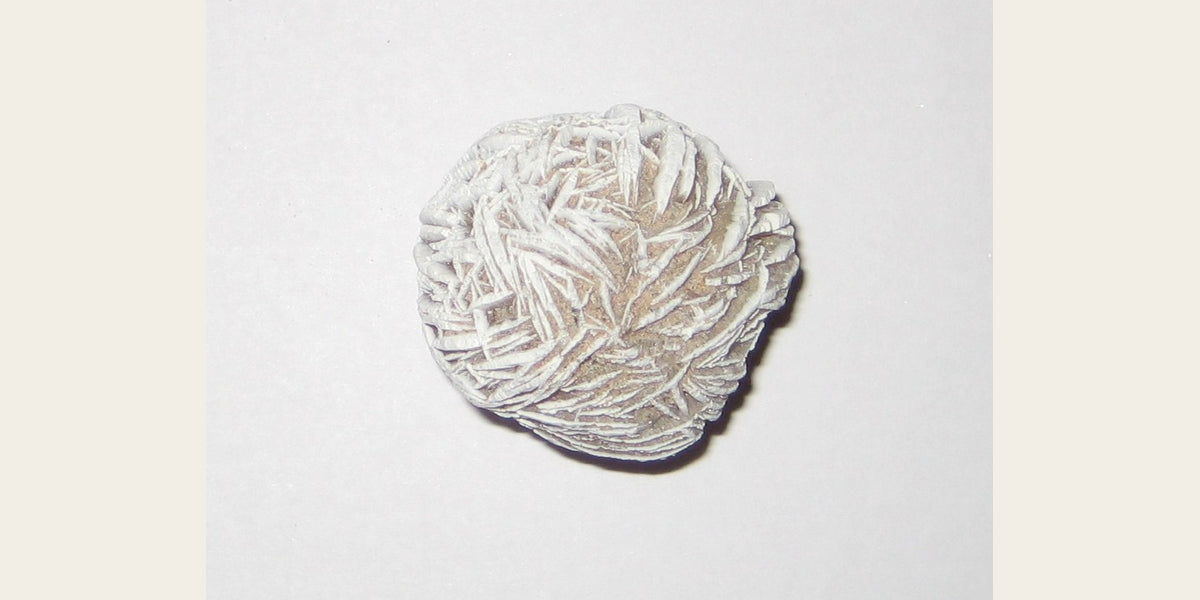 Gypsum desert rose specimen; photo by Stephanie Clifford, CC BY 2.0 — Roosters Peacock crystal guide