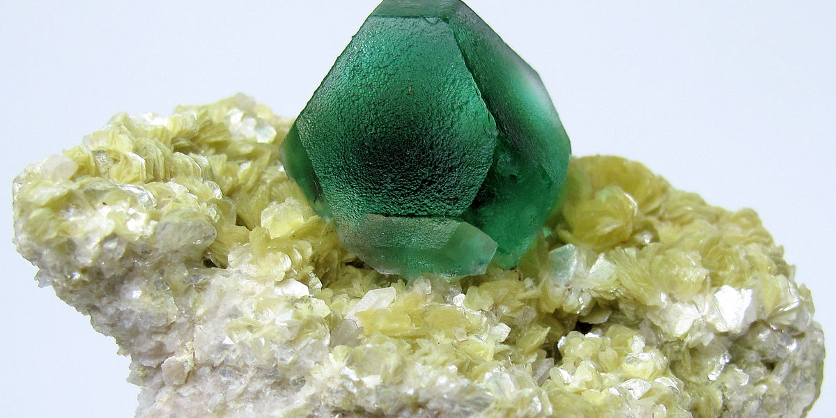 Green fluorite crystal on micaceous matrix from Namibia; photo by CarlesMillan, CC BY-SA 3.0 — Roosters Peacock crystal guide