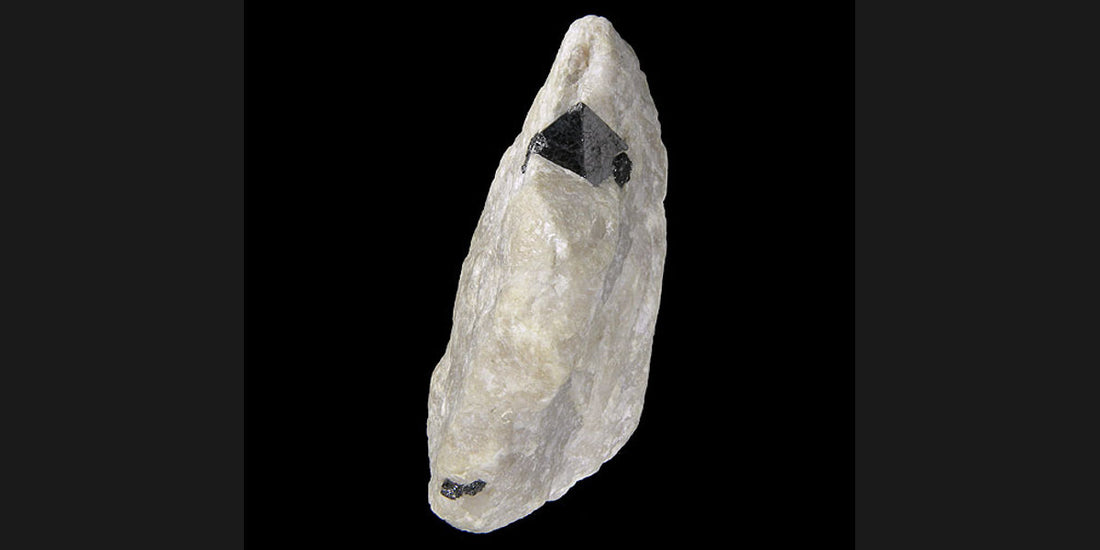 Franklinite crystal on calcite matrix from Franklin, New Jersey; photo by Robert M. Lavinsky, CC BY-SA 3.0 — Roosters Peacock crystal guide
