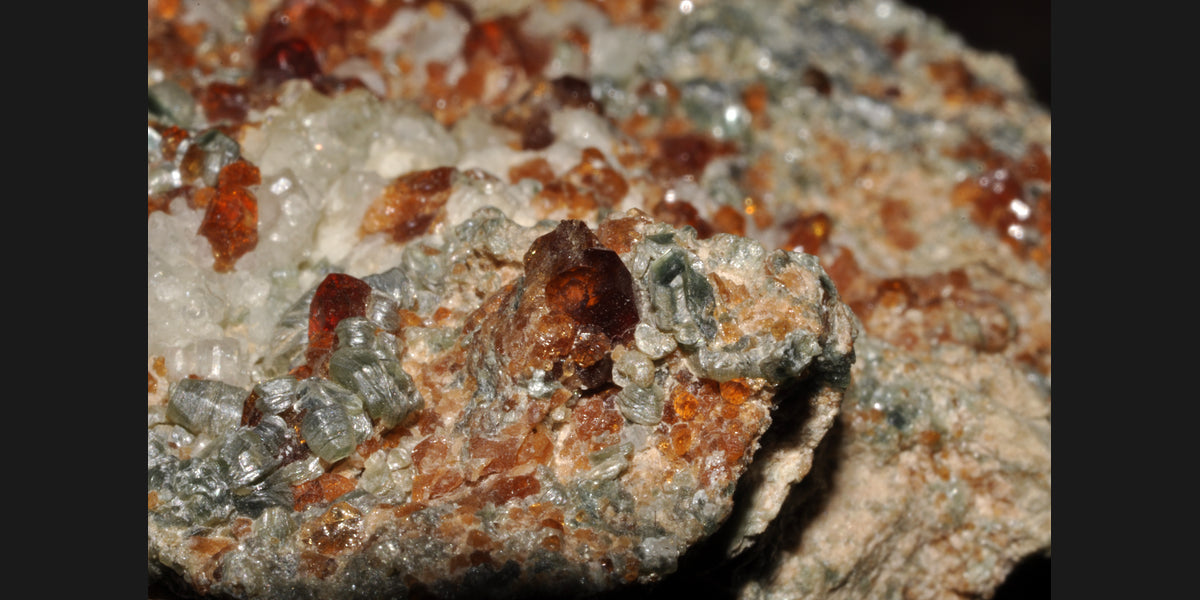 Hessonite garnet crystals with clinochlore from Italy; photo by Géry Parent, public domain — Roosters Peacock crystal guide