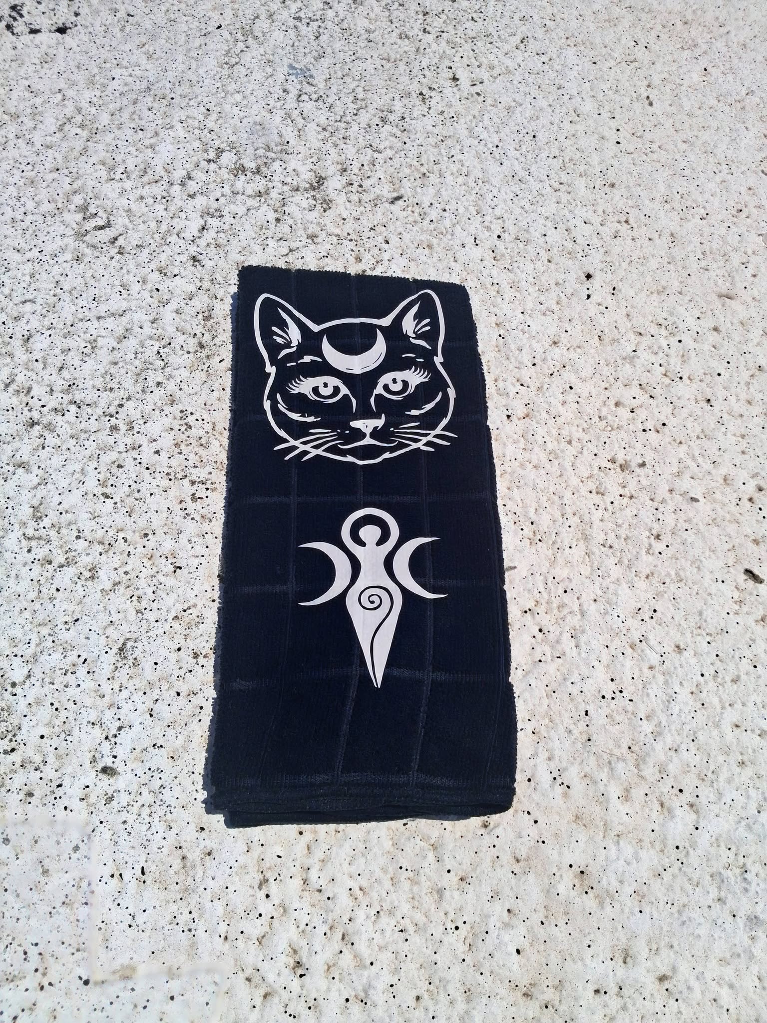 Black microfiber moon cat Triple Goddess hand towel full view on concrete showing complete white design