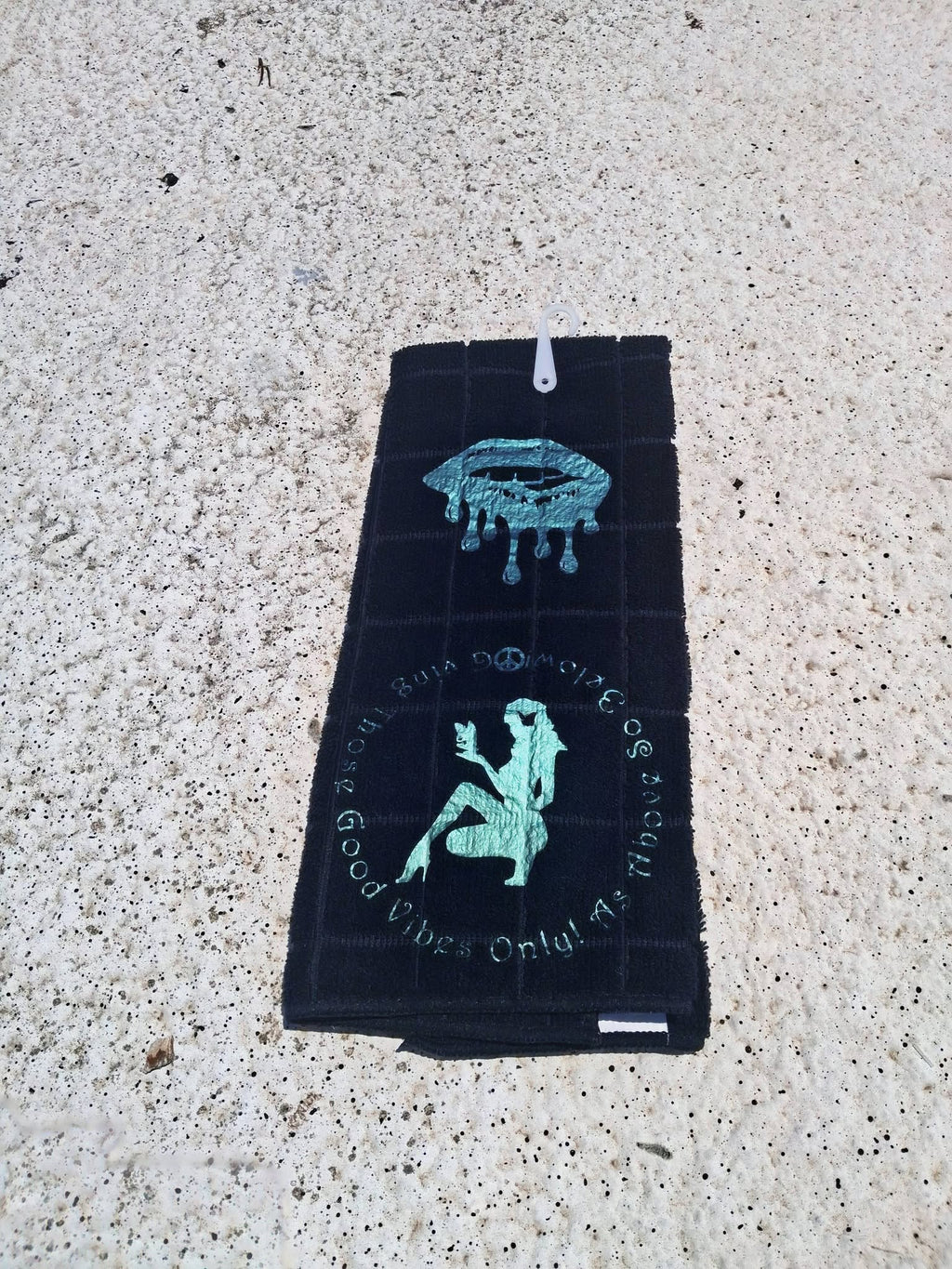 Gray microfiber Good Vibes Only hand towel close up showing teal dripping lips and circular text detail