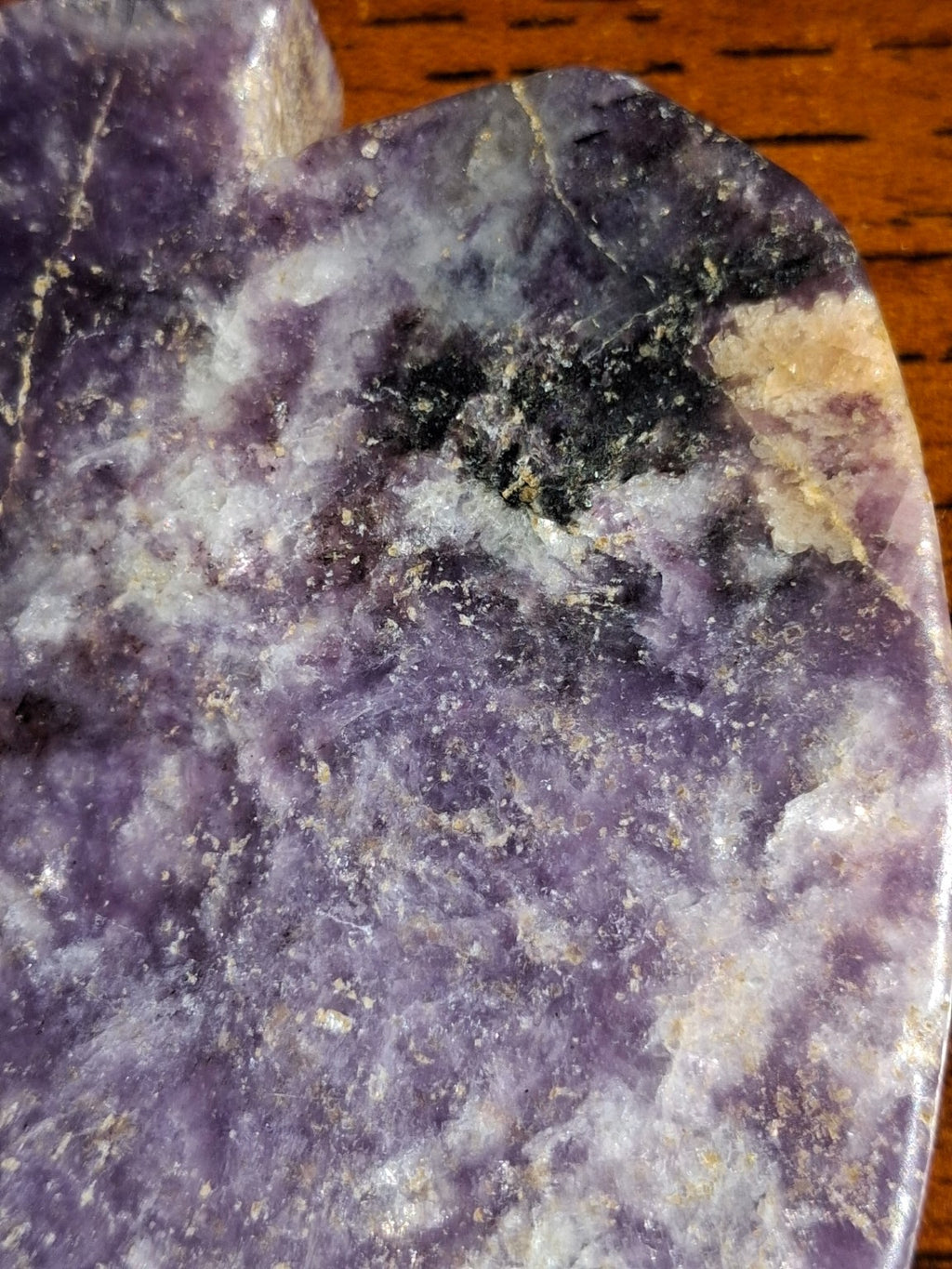 Close-up dark natural mineral inclusions near the shoulder of amethyst pumpkin carving