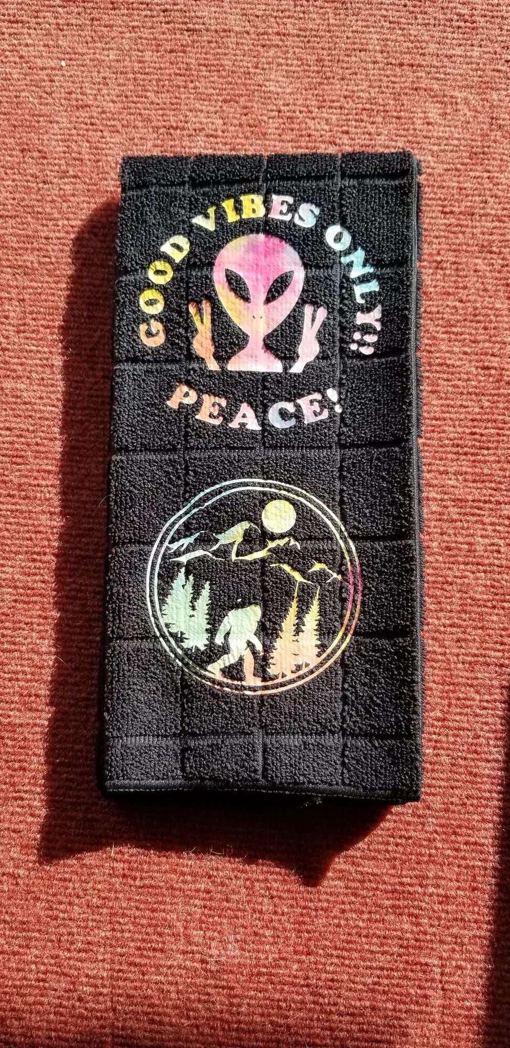 Black microfiber hand towel with holographic groovy alien Good Vibes Only and Bigfoot designs handmade by Roosters Peacock
