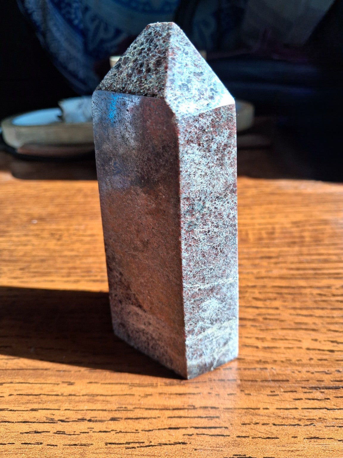 Garnet in matrix crystal point tower side view with reddish brown side and silvery gray host matrix