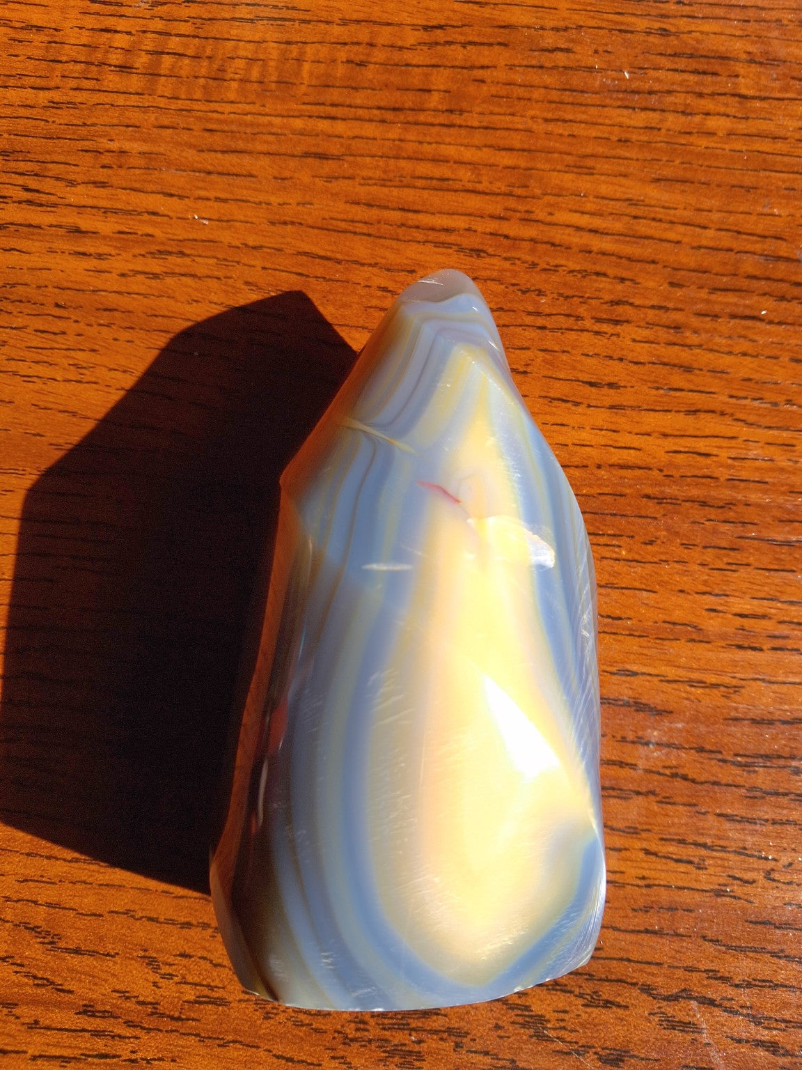 Orca Agate flame top-down angled photograph showing ivory gray concentric banding