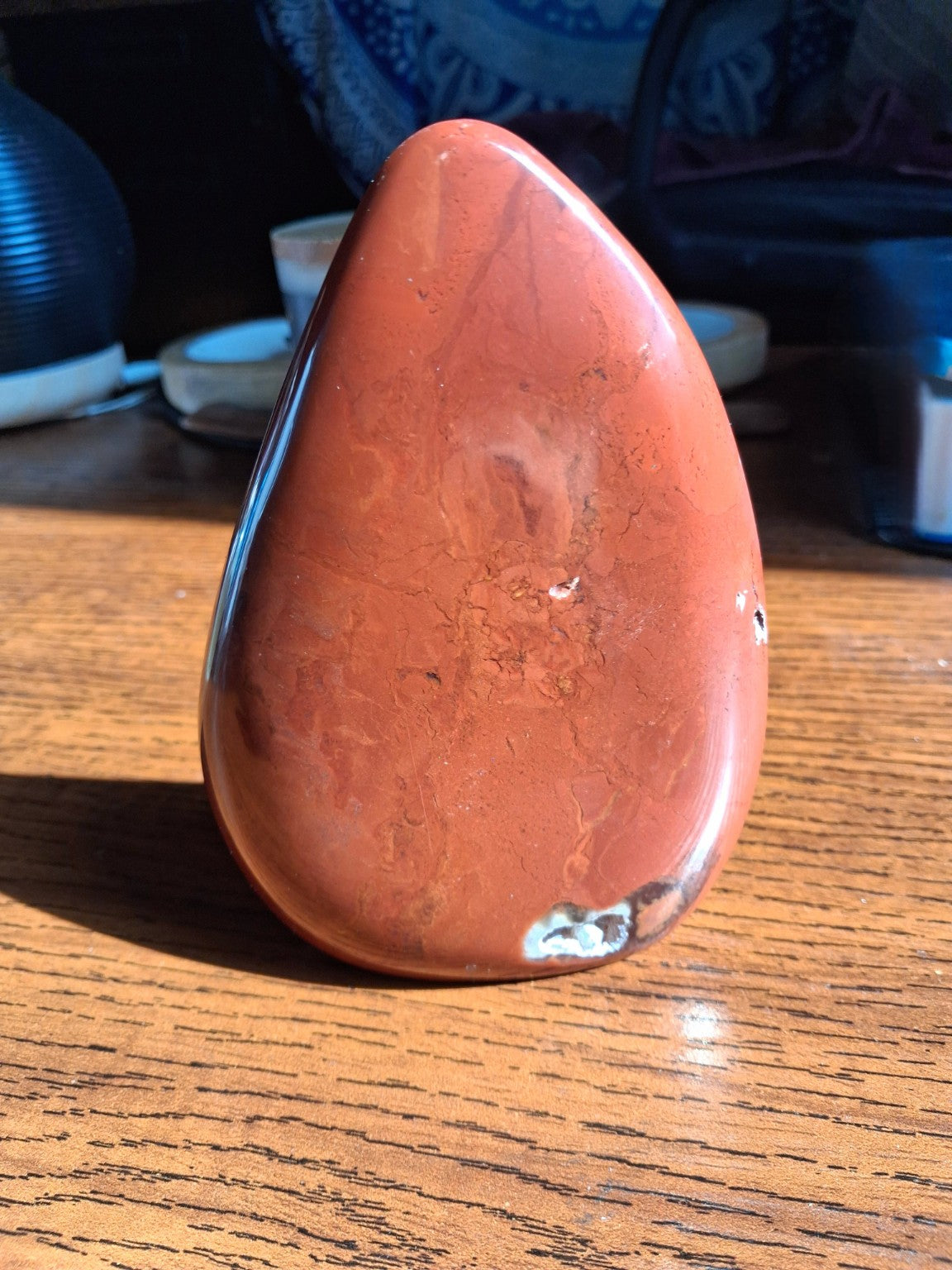 Red Jasper polished freeform 5 inch front view, warm rust red with unique pale mineral pocket at bottom
