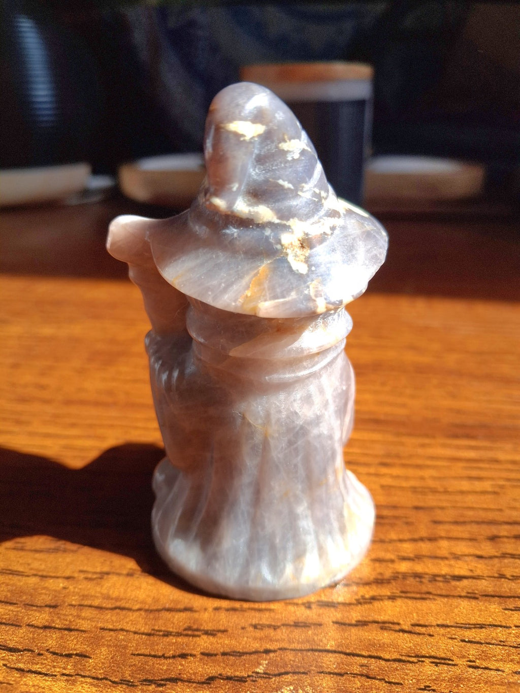 Back of amethyst pumpkin witch carving showing smoky lavender-gray and pale cream bands, original stone photo