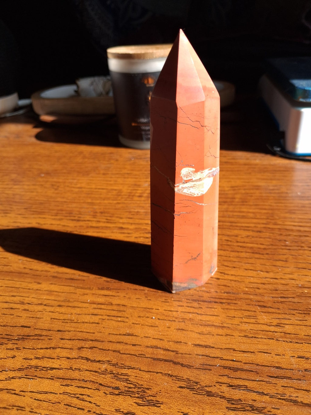 Original front three-quarter photo of the 5¾-inch red jasper polished tower with pointed tip, pale cream middle band, and dark branching veins
