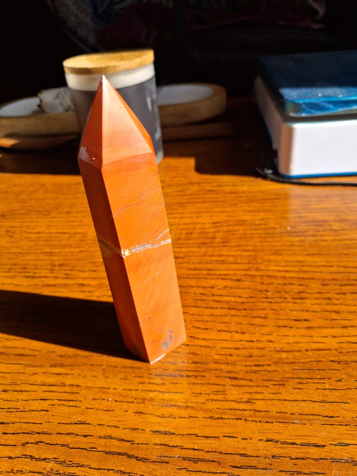 Original opposite angled side view of slender 5¾-inch red jasper faceted point and flat standing base